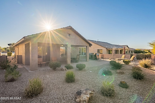 back of property featuring a patio area and an outdoor fire pit