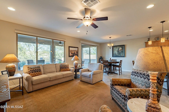 living room with ceiling fan with notable chandelier