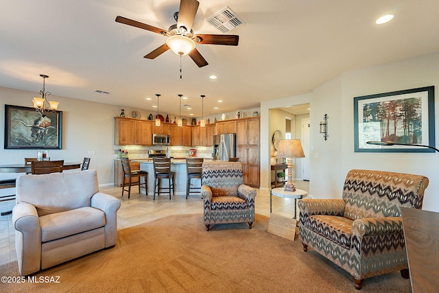 tiled living room with ceiling fan with notable chandelier