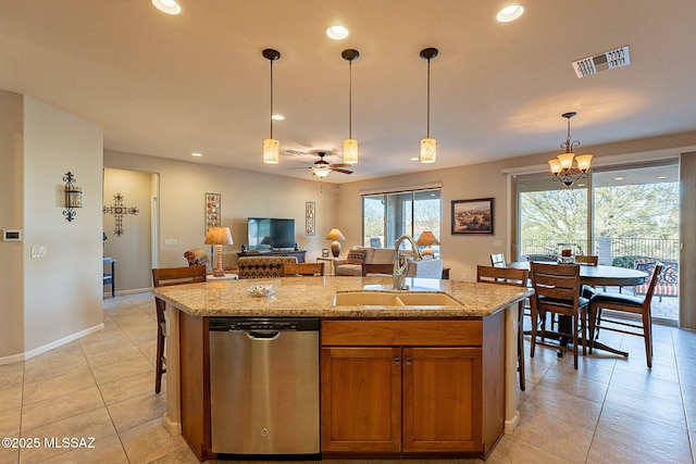 kitchen with dishwasher, a kitchen island with sink, ceiling fan with notable chandelier, sink, and light stone counters