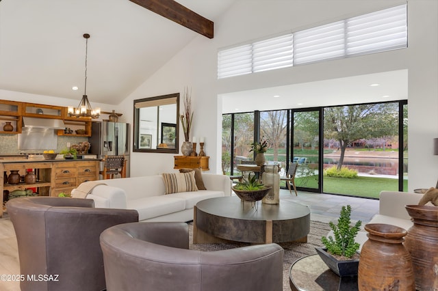 living room featuring beam ceiling, high vaulted ceiling, and an inviting chandelier