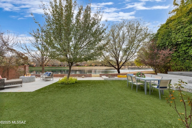 view of yard with a patio, a water view, and a fire pit