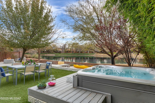 view of pool with a water view, a lawn, and an outdoor hot tub