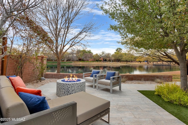 view of patio featuring a water view and an outdoor living space with a fire pit