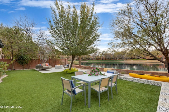 view of yard featuring a water view, a patio, and an outdoor living space with a fire pit