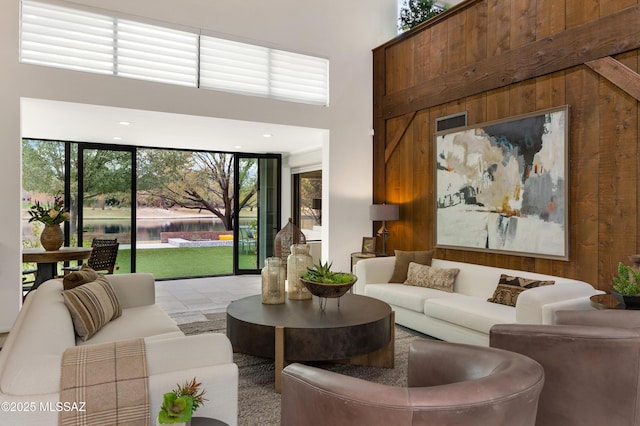 living room with a high ceiling and wooden walls