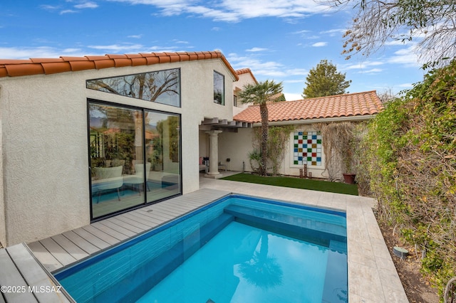 rear view of house with a pool side deck