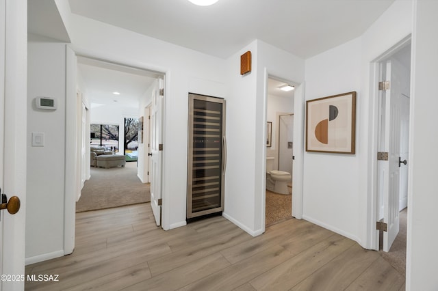 hall with beverage cooler and light wood-type flooring