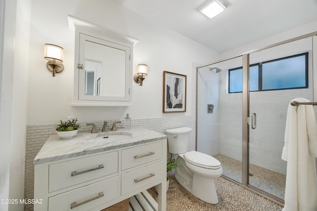 bathroom featuring tile patterned floors, toilet, vanity, and walk in shower