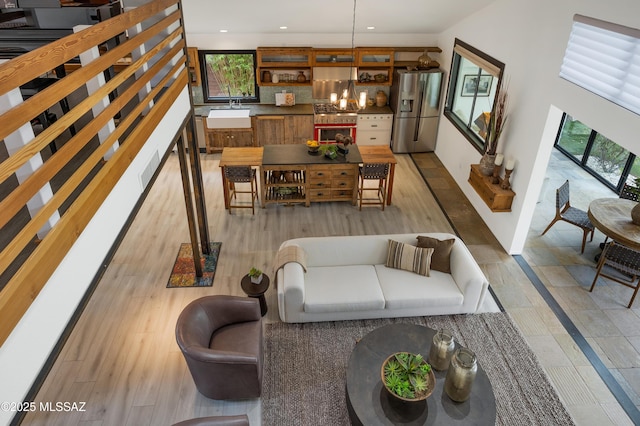 living room with a notable chandelier, light hardwood / wood-style floors, and sink