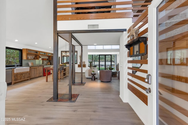 interior space featuring sink, vaulted ceiling, and light wood-type flooring