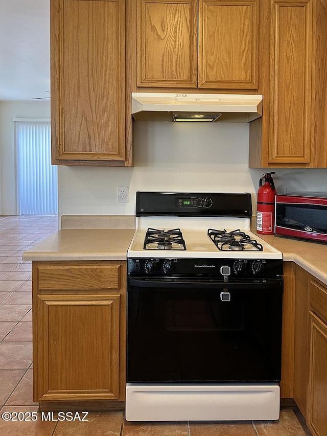 kitchen with gas range and light tile patterned flooring