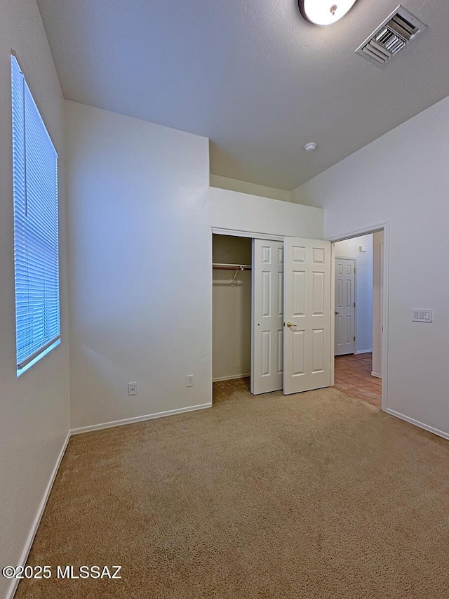 unfurnished bedroom with a closet and carpet flooring