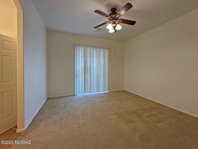 carpeted spare room featuring ceiling fan