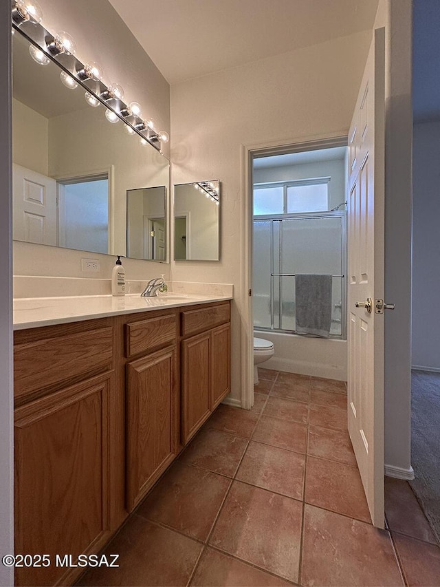 full bathroom with vanity, combined bath / shower with glass door, tile patterned floors, and toilet