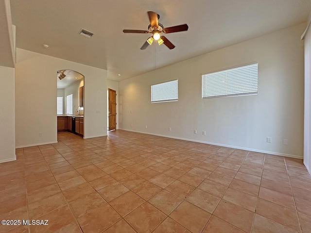 tiled spare room with ceiling fan