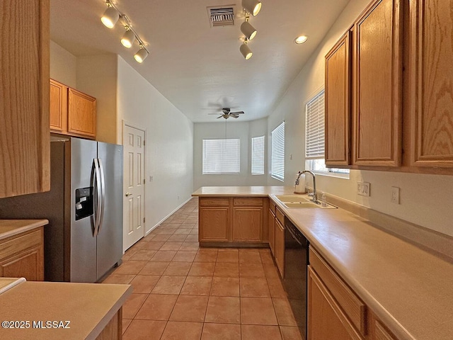 kitchen featuring black dishwasher, sink, stainless steel fridge, light tile patterned floors, and kitchen peninsula