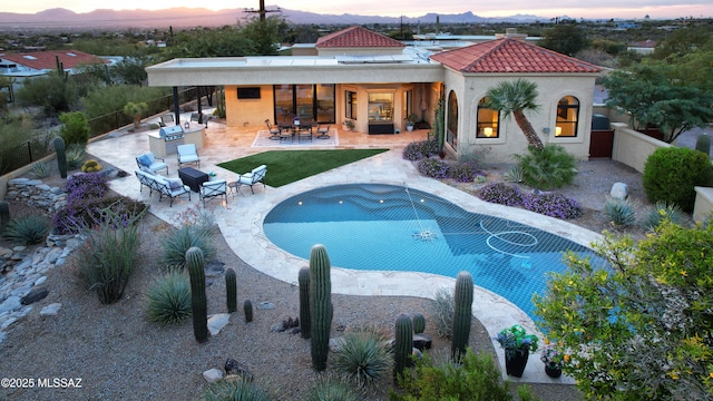 pool at dusk featuring a patio area