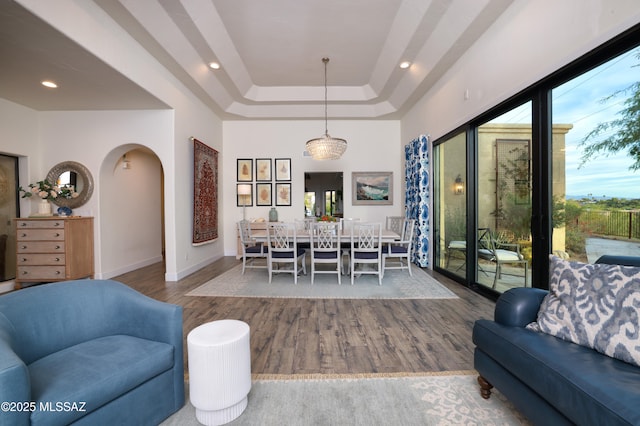 living room with a tray ceiling and wood-type flooring