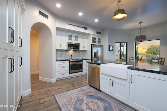 kitchen with hanging light fixtures, white cabinets, stainless steel appliances, and sink