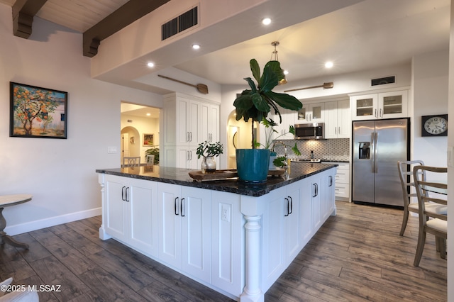 kitchen with appliances with stainless steel finishes, a center island, dark hardwood / wood-style floors, and white cabinetry