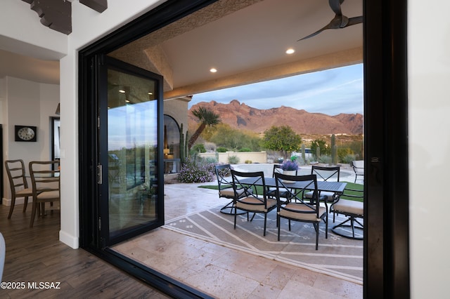 doorway with a mountain view, hardwood / wood-style flooring, and ceiling fan