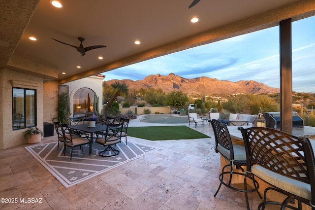 view of patio / terrace with a mountain view, outdoor lounge area, ceiling fan, and a swimming pool