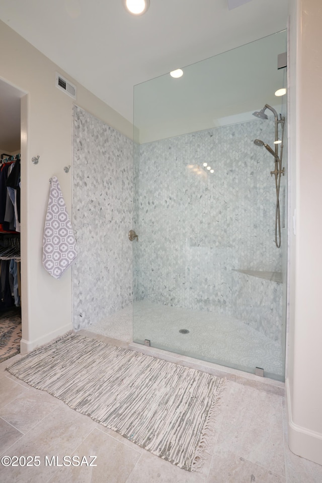 bathroom featuring tiled shower and tile patterned floors