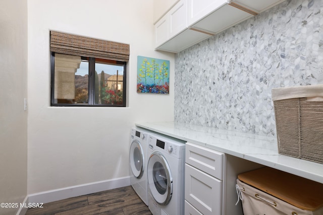 clothes washing area featuring washer and dryer, dark wood-type flooring, and cabinets