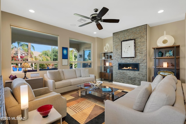 living room with a fireplace, hardwood / wood-style flooring, and ceiling fan