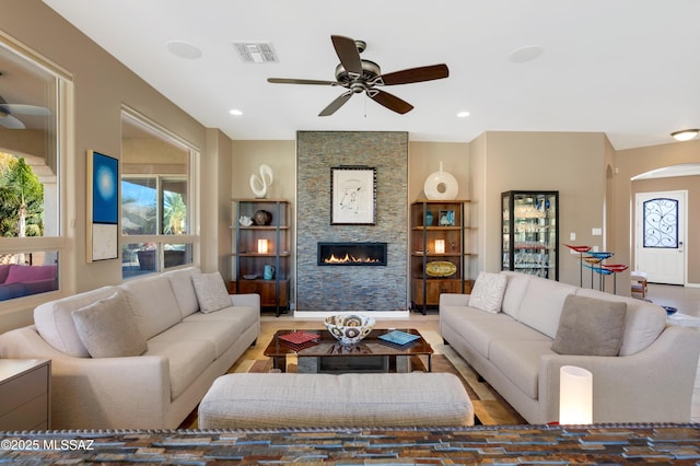 living room featuring ceiling fan and a fireplace