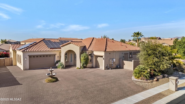 mediterranean / spanish home with solar panels and a garage