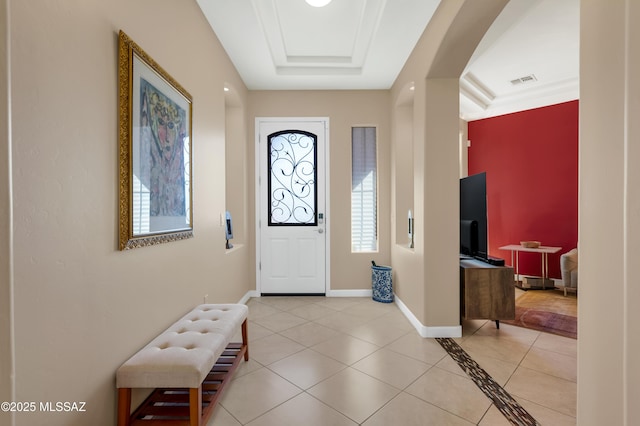 tiled entrance foyer with a tray ceiling