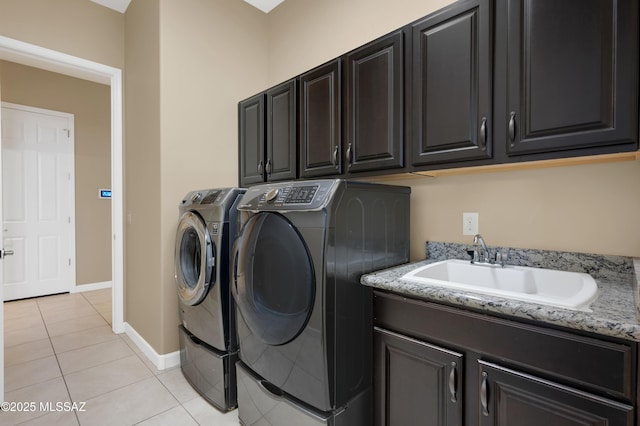 clothes washing area featuring cabinets, sink, washing machine and dryer, and light tile patterned flooring