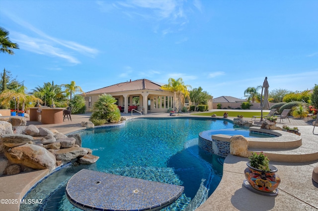 view of swimming pool featuring an in ground hot tub, pool water feature, and a patio area