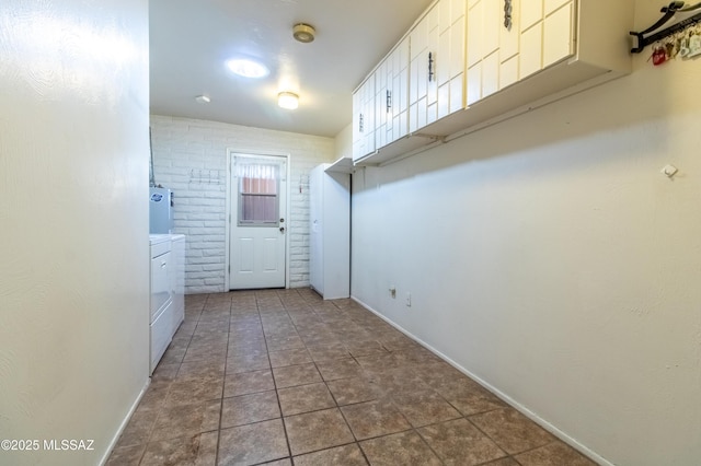 laundry area featuring brick wall and independent washer and dryer