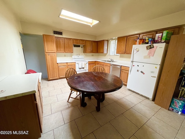 kitchen with sink, white appliances, and light tile patterned floors