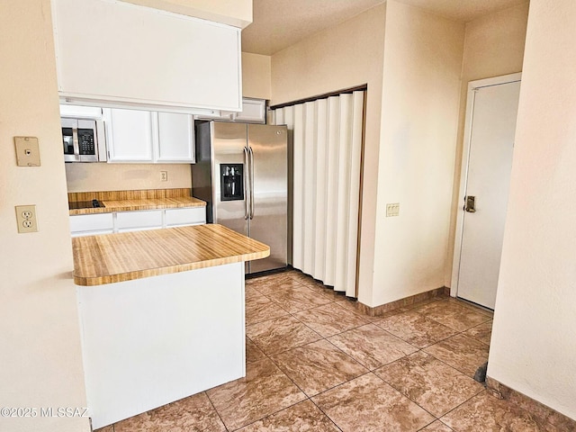 kitchen featuring stainless steel appliances and white cabinets