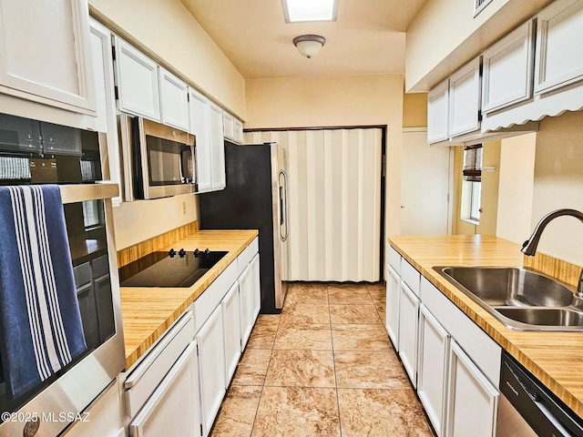 kitchen with stainless steel appliances, sink, and white cabinets