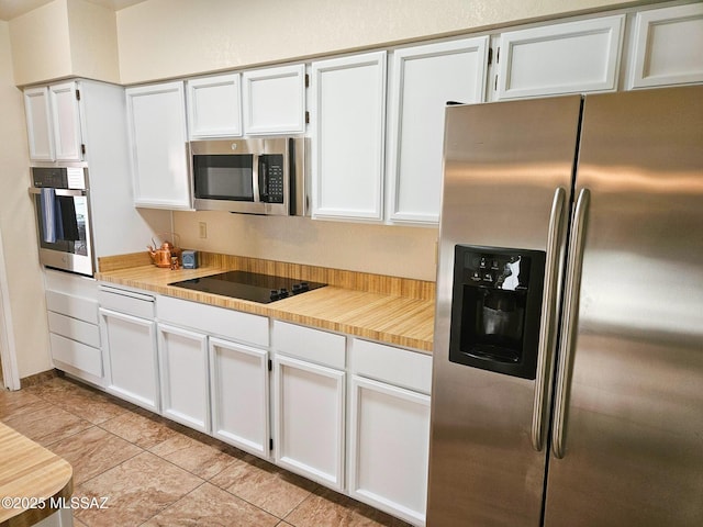 kitchen featuring white cabinetry, stainless steel appliances, and light tile patterned flooring