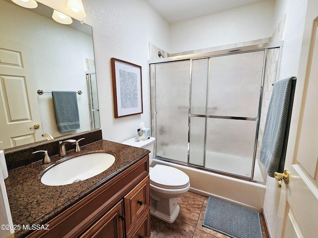 full bathroom with vanity, tile patterned floors, shower / bath combination with glass door, and toilet