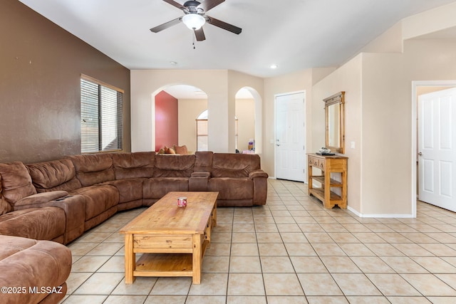 living area with light tile patterned floors, ceiling fan, arched walkways, recessed lighting, and baseboards