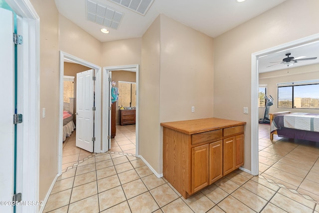 hall with light tile patterned floors, baseboards, visible vents, and recessed lighting