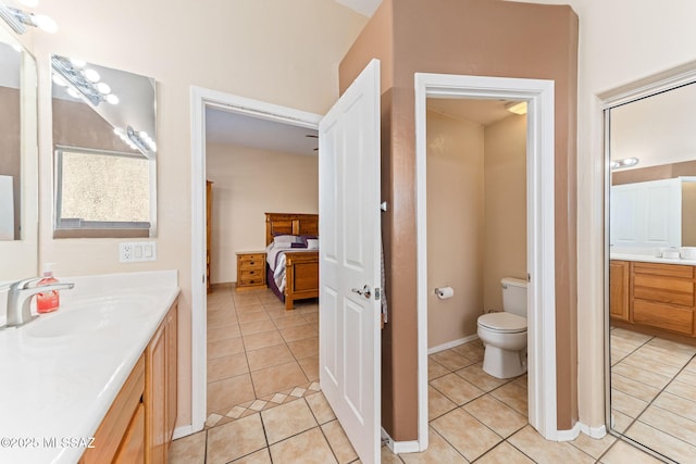 ensuite bathroom featuring baseboards, toilet, ensuite bath, tile patterned flooring, and vanity