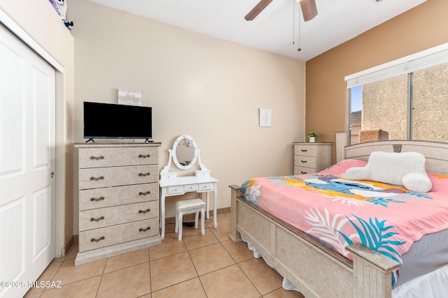 bedroom with light tile patterned floors, a closet, and a ceiling fan