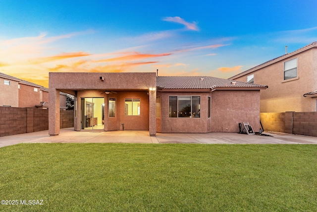 back of property featuring a patio, a yard, a fenced backyard, and stucco siding