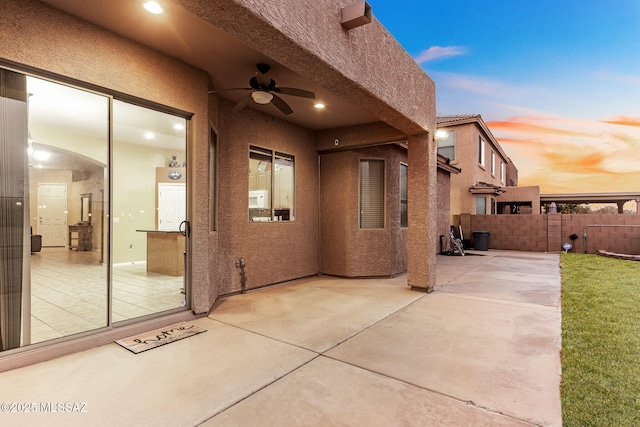 patio terrace at dusk featuring ceiling fan