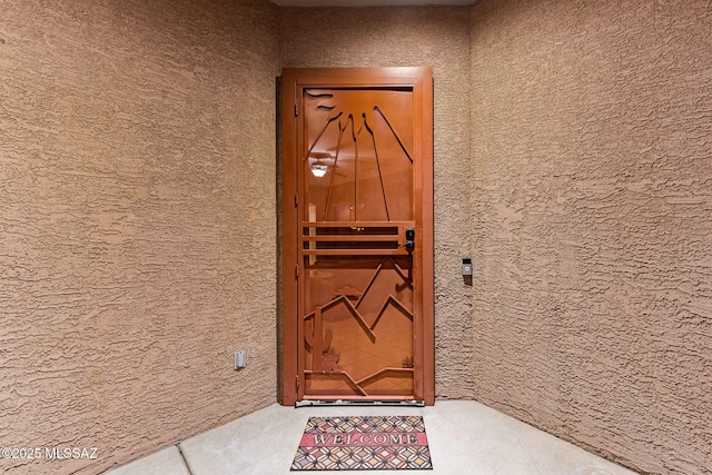 doorway to property featuring stucco siding