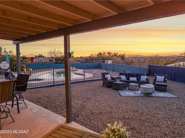 patio terrace at dusk featuring an outdoor hangout area and a fenced in pool