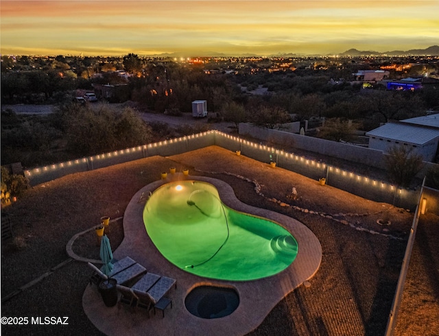 pool at dusk featuring a patio area